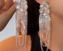 A close-up of a woman wearing luxurious crystal tassel earrings with marquise stones, adding a touch of glamour to her outfit.