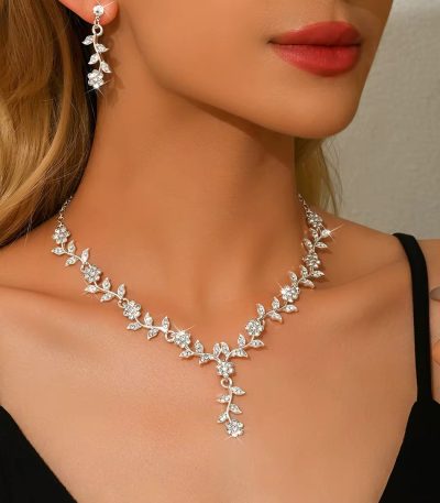 A woman wearing a luxurious floral diamond necklace and matching earrings, showcasing the perfect blend of elegance and refinement.