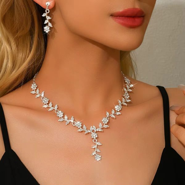 A woman wearing a luxurious floral diamond necklace and matching earrings, showcasing the perfect blend of elegance and refinement.