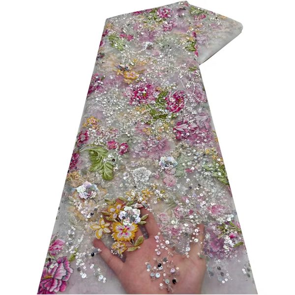 A hand holding a section of exquisite floral sequined tulle fabric, showcasing its intricate details and luxurious texture.