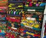 A colorful stack of African print fabrics with unique designs and patterns, perfect for fashion and textile enthusiasts.