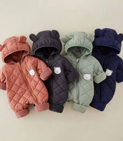 Four quilted rompers in assorted colors - salmon, dark grey, light green, and navy blue - with bear ears and white bear patches on the chest, laid out on a cream background.