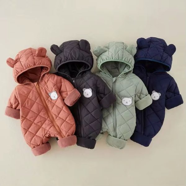 Four quilted rompers in assorted colors - salmon, dark grey, light green, and navy blue - with bear ears and white bear patches on the chest, laid out on a cream background.