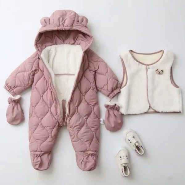 A beautifully arranged flat lay of a pink teddy bear baby snowsuit set, complete with mittens, a matching vest, and shoes on a white background.